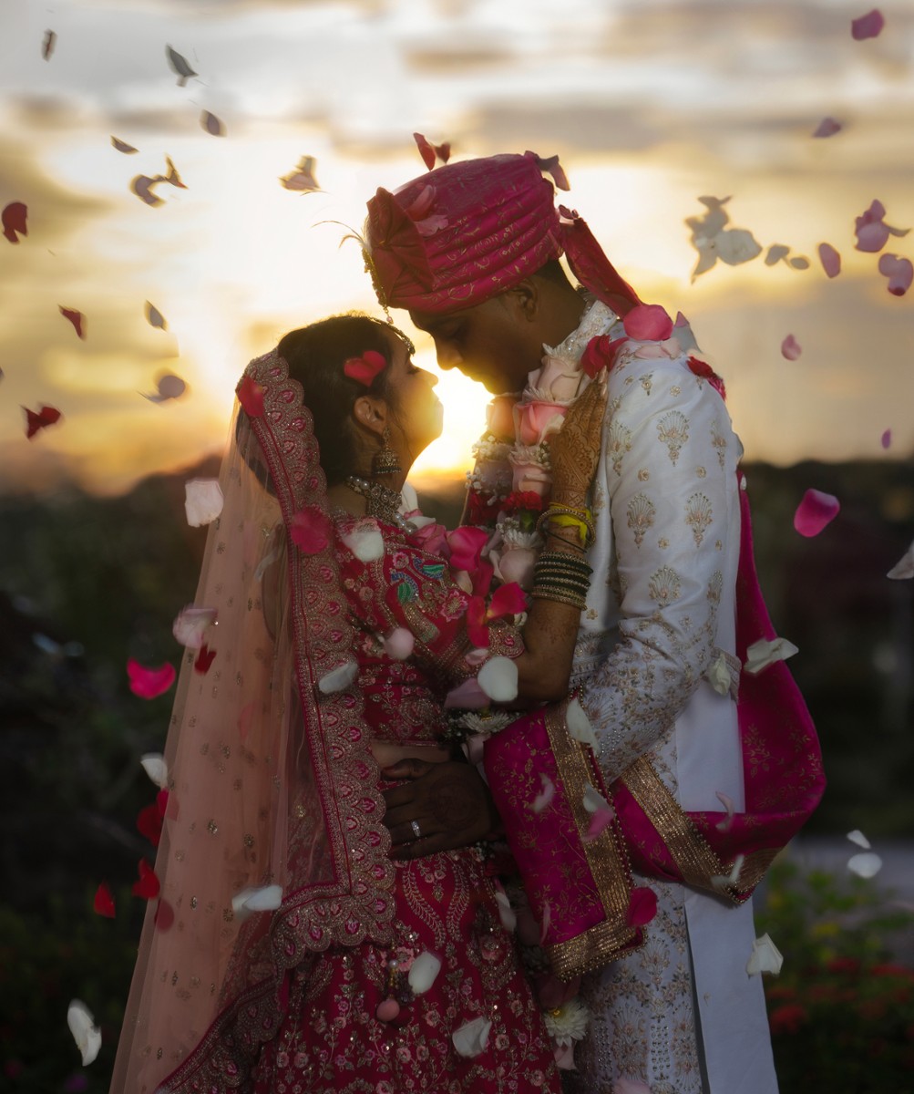 Hindu wedding couple surrounded by falling rose petals