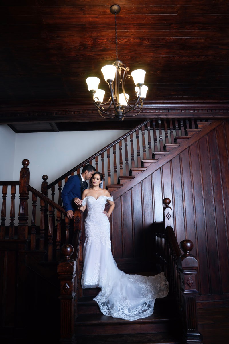 Wedding couple posed on a dramatic wooden staircase